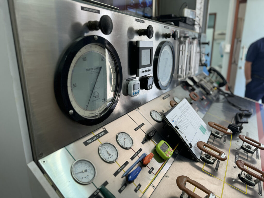 Chamber operator at the external control console - depth gauges, oxygen analyzer, chamber communicator and closed-circuit video of the patient inside